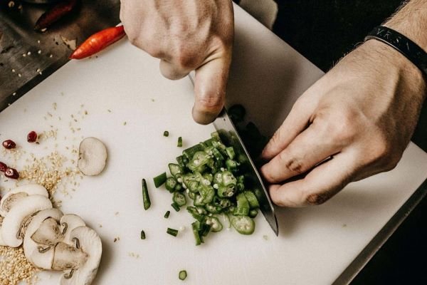 A chef chopping green onions